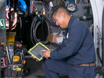 Technician servicing equipment at a job site.